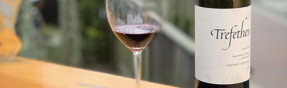 Steak on a 19 Prime cutting board with a glass and wine bottle